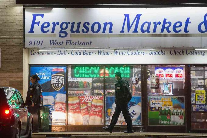 Полицейские перед Ferguson Market & Liquor во время беспорядков 2014 года в Фергюсоне, штат Миссури.